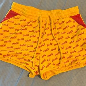 Coca-Cola Yellow Shorts with Red Logo Pattern